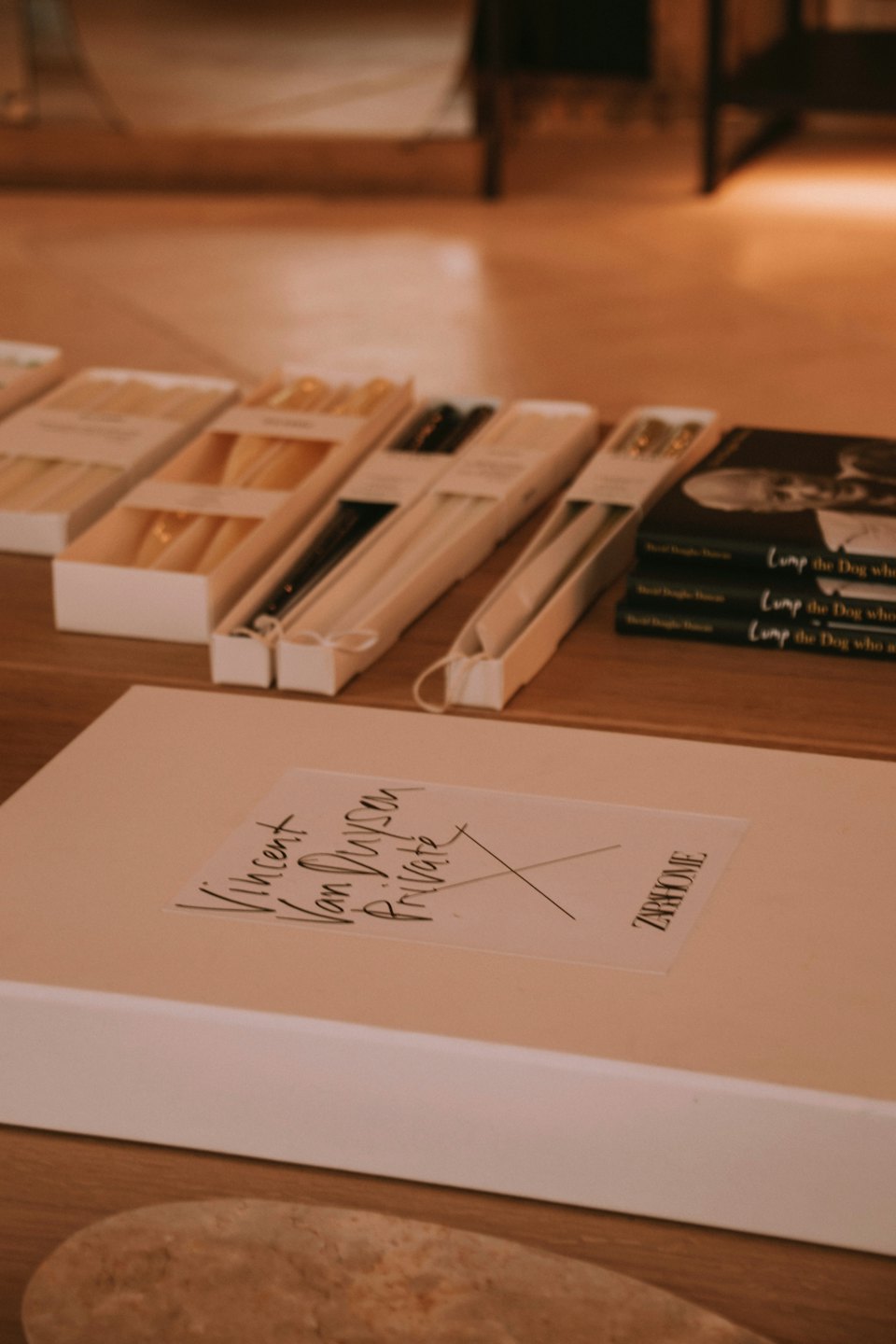 Retail boxes and stacked books arranged on a wooden table.
